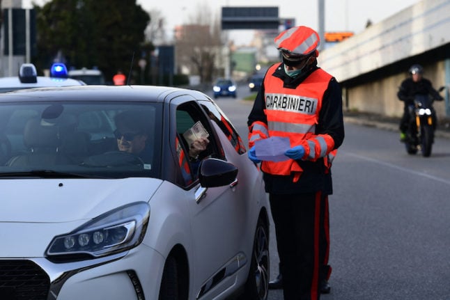A carabinieri police officer checks a driving licence.