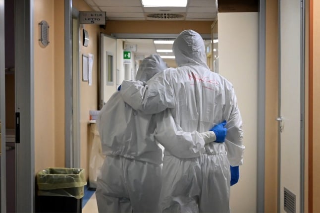 Medical workers in protective gear react at the end of their shift in an intensive care unit treating COVID-19 patients at the San Filippo Neri hospital in Rome on April 20, 2020.