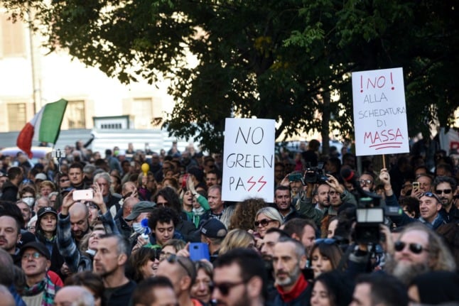 People gather during a protest against the green pass in Milan on October 16, 2021.