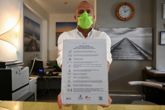 A hotel owners shows a list of safety rules and precautions for customers against the spread of Covid-19.