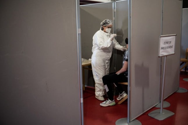 A student is tested with an antigenic Covid-19 test in France by a woman dressed in full PPE. 