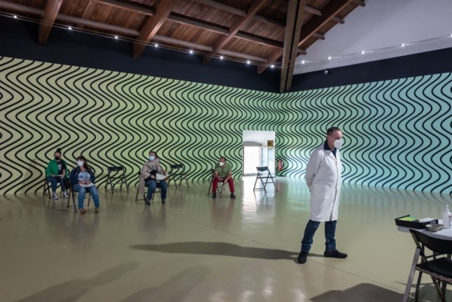 People wait to receive a dose of the Moderna Covid-19 vaccine at the Museum of Contemporary Art "Castello di Rivoli" near Turin on May 27, 2021.
