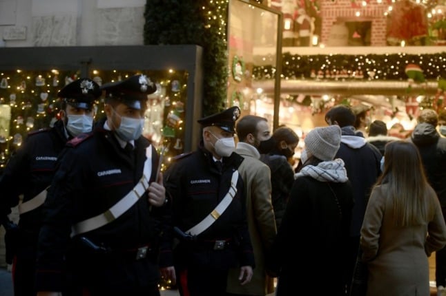 Carabinieri police patrol as people do their Christmas shopping in central Rome.