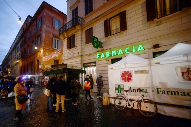 People queue for coronavirus tests outside a pharmacy in Rome.