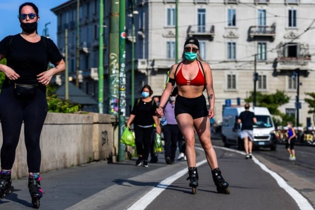 People roller skate along the Navigli canals in Milan on May 8, 2020