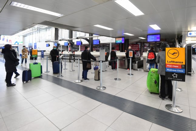 Passengers keep a safe distance while checking in at Milan's Linate airport. 